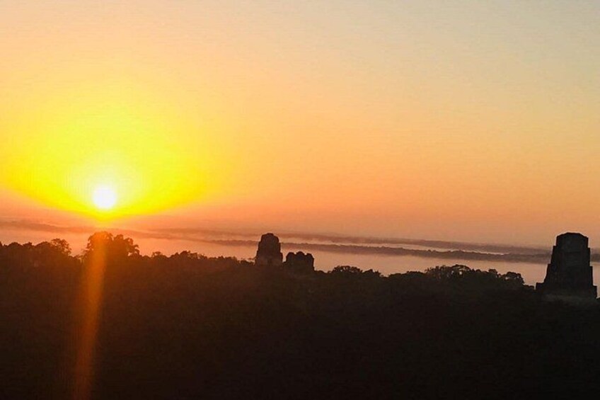 A sunset over a landscape with rock formations. 3