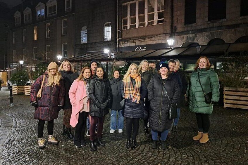 A group of people standing in front of a building with a sign that reads 'Pub.' 5