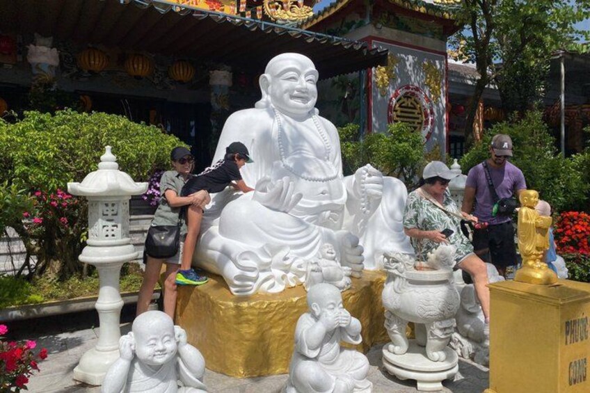 En stor vit Buddhastaty omgiven av mindre statyer och en pagod i bakgrunden. 2