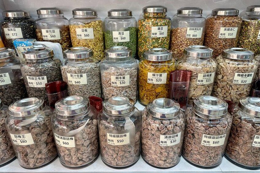 A variety of jars filled with different types of grains and legumes, each labeled with a price. 3