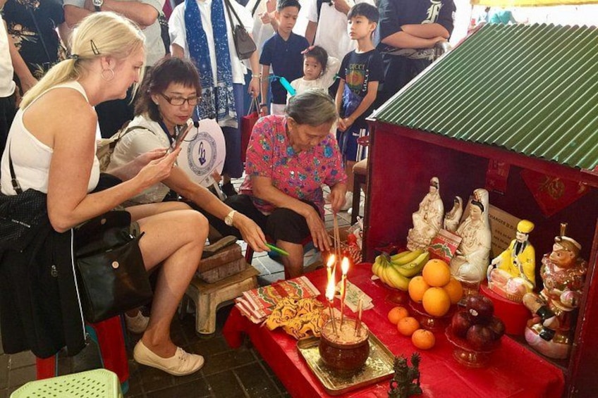 A group of people around a table with candles, fruits, and religious statues. 1