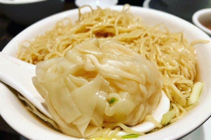 A bowl of noodles with a dumpling. 5