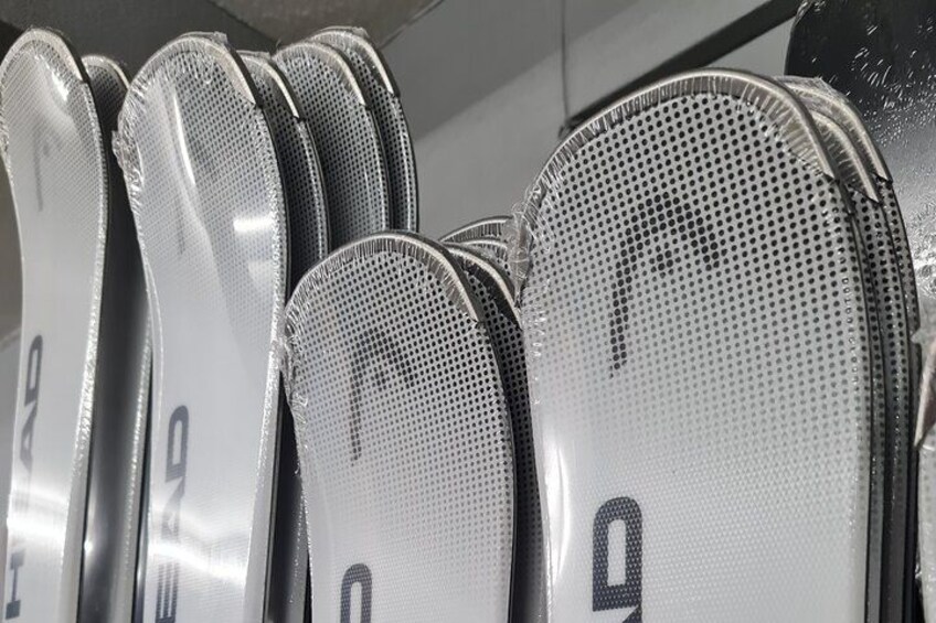 A row of skis with visible numbers and a textured surface. 2