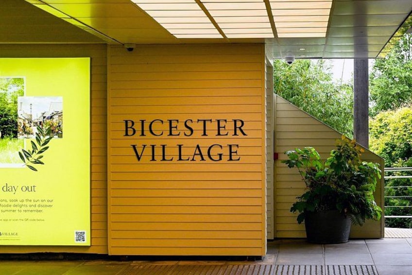 Un bâtiment jaune sur lequel on peut lire l’inscription « BICESTER VILLAGE ». 1