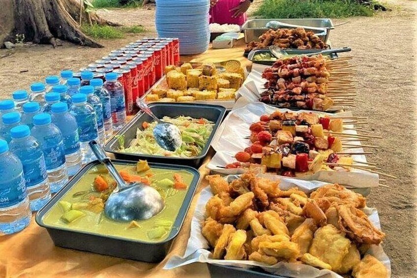 Une table de buffet avec divers plats et des bouteilles d’eau. 4