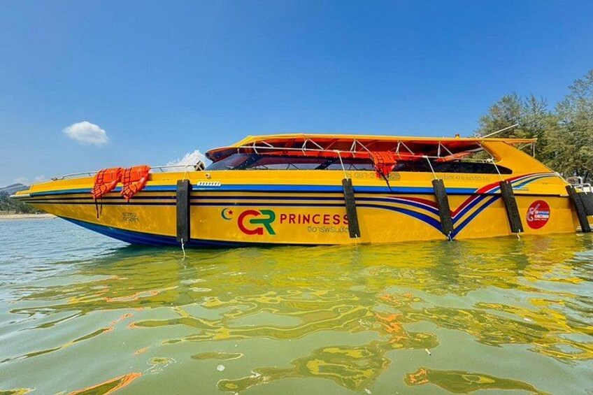 Un bateau jaune nommé « Princess », orné d’un logo rouge et vert, flotte sur l’eau. 2