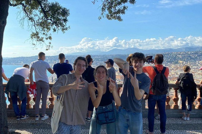A group of people standing on a viewing platform overlooking a city with mountains in the background. 3