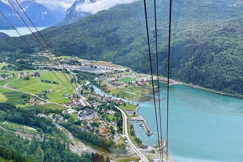 Ett kuperat landskap med en flod, en bro och en liten stad. 2