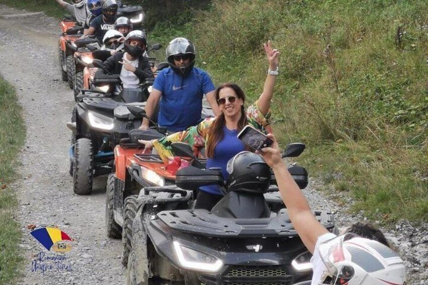 A group of people on ATVs on a dirt path surrounded by greenery. 2