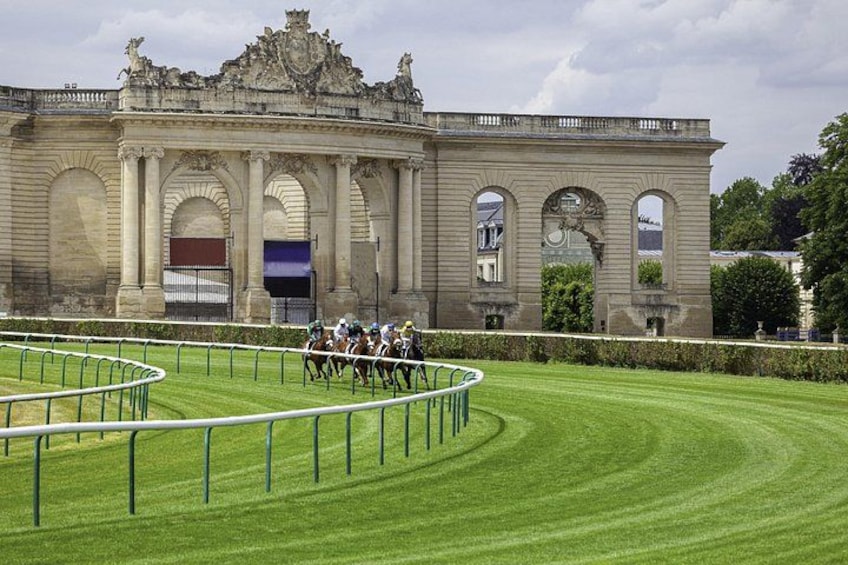 Un bâtiment historique à l’architecture riche et élaborée, doté d’une pelouse bien entretenue et d’une piste d’entraînement pour les chevaux. 3