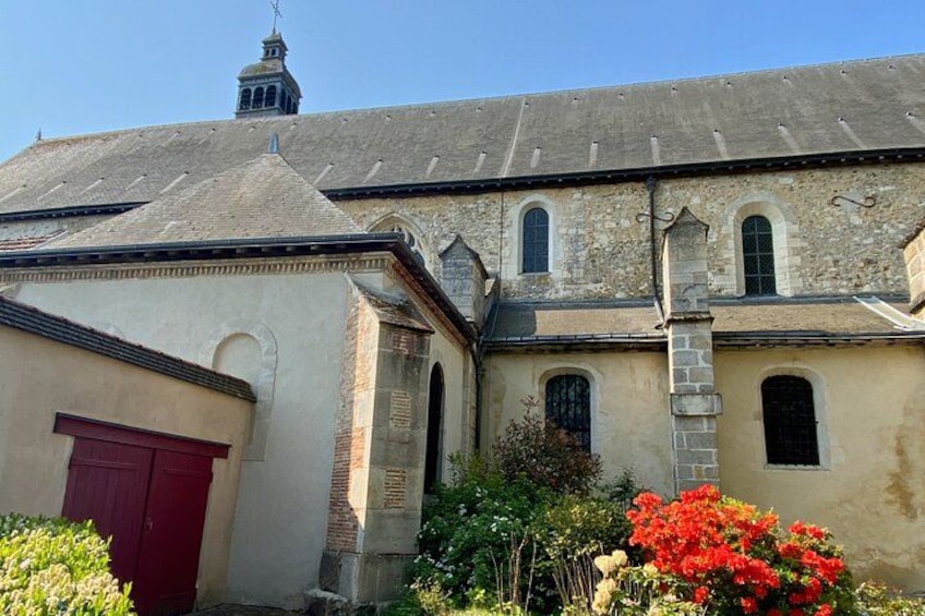 A historic building with a red door, arched windows, and a bell tower. 2