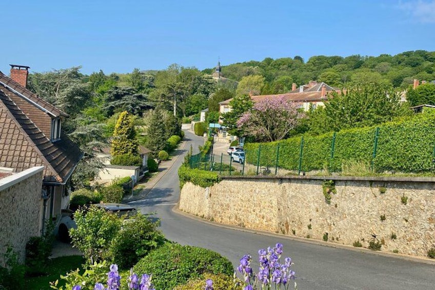 A narrow road in a rural area with stone walls and houses on either side. 3