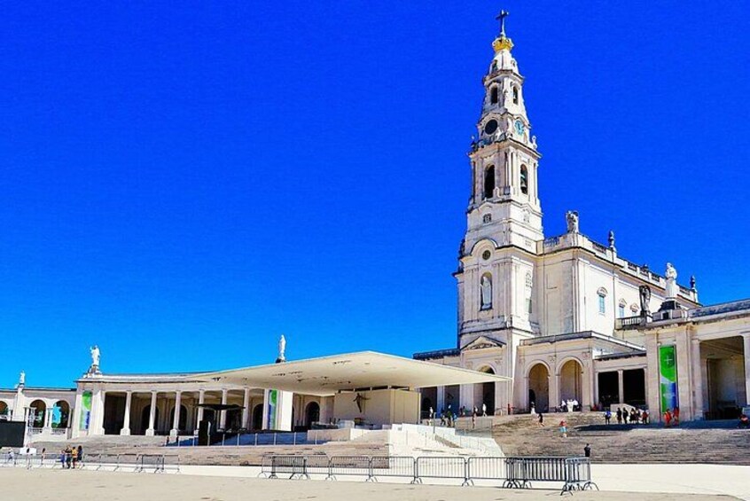 Un grand bâtiment blanc, doté d’une haute tour, d’une galerie couverte et surplombé d’un ciel d’un bleu éclatant. 3