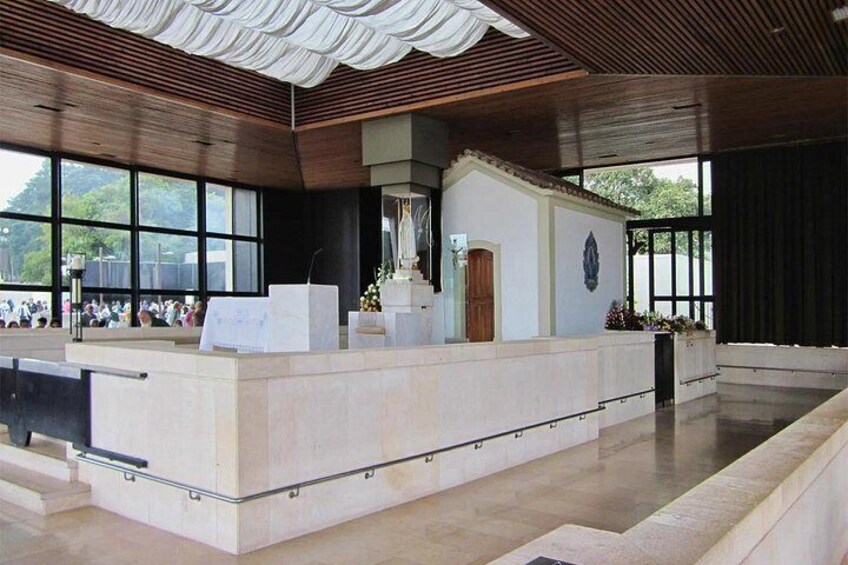 Un interior moderno con una mesa de recepción, ventanas amplias y un techo decorativo. 3