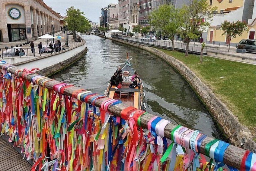 Un río con un bote, cintas de colores y edificios a lo largo de las orillas. 4