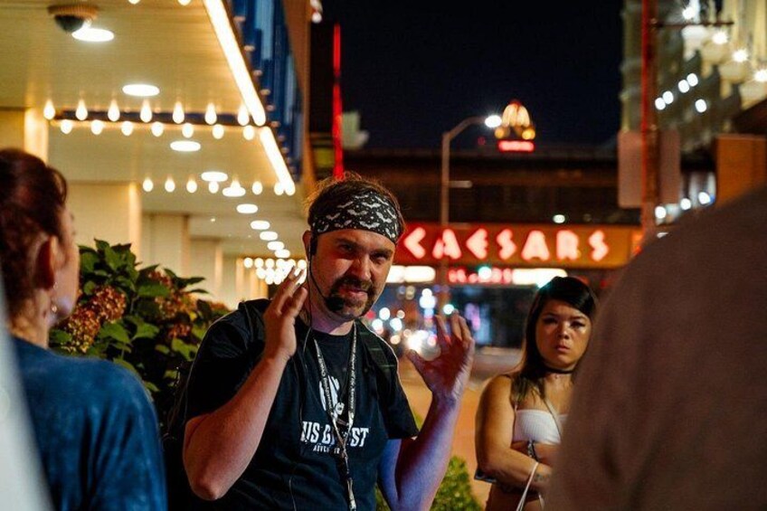 A person wearing a black t-shirt with 'US BEST' text, standing outdoors at night with string lights in the background. 2