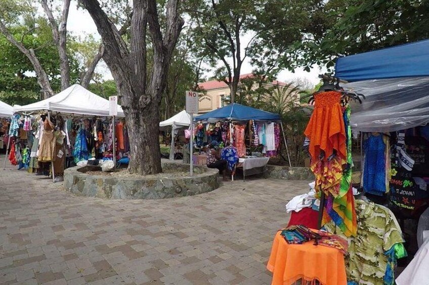 Outdoor market stalls with various colorful textiles and clothing items. 2