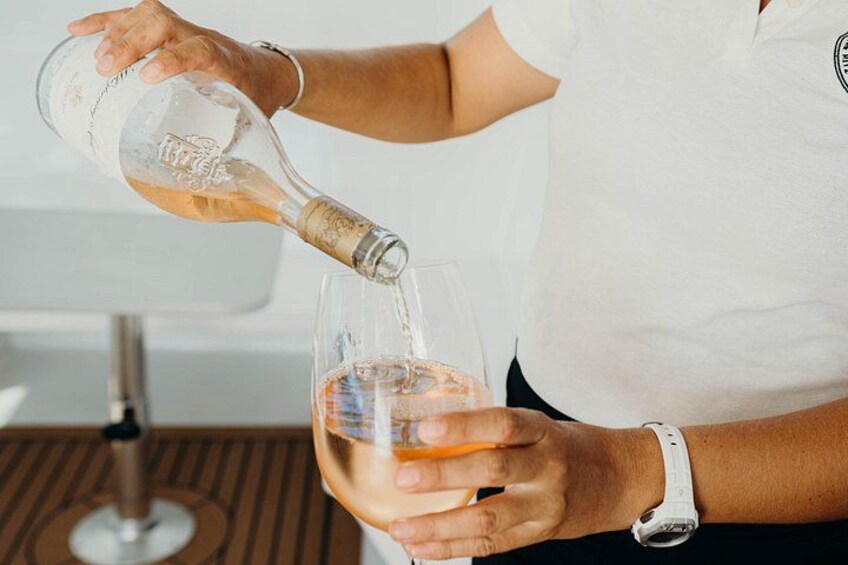 A person pouring a clear liquid from a bottle into a glass. 4
