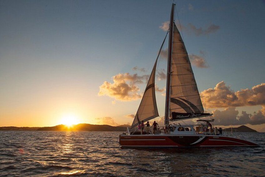 A sailboat with two sails on a calm sea during sunset. 2