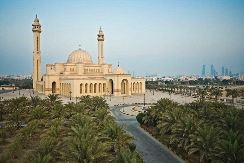 Eine Moschee mit zwei Minaretten, einer großen Kuppel und Dattelpalmen im Vordergrund. 4