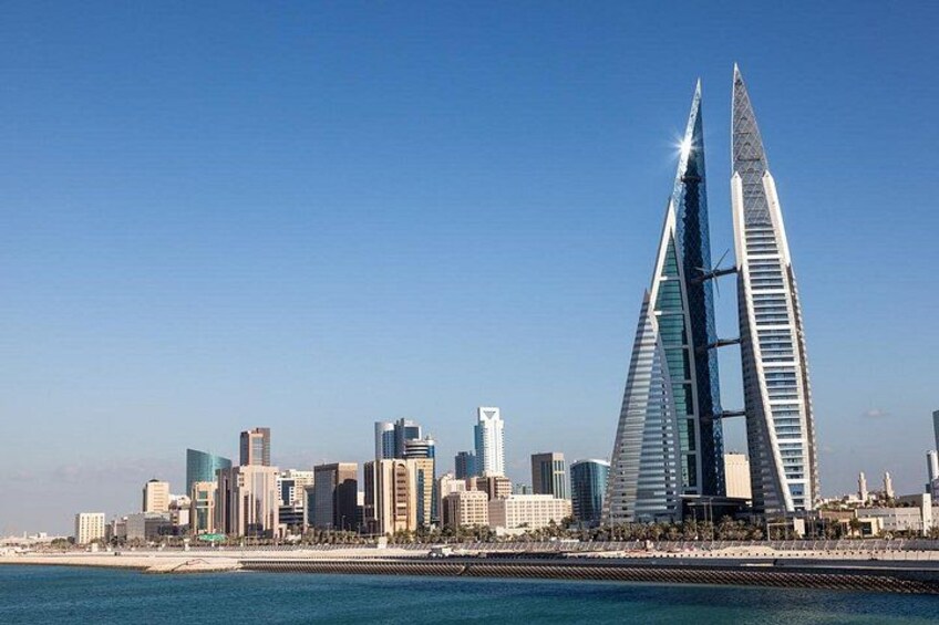 Eine Küstenstadt mit einem beeindruckenden Wolkenkratzer-Horizont, darunter ein markantes Doppeltürmige Gebäude. 5