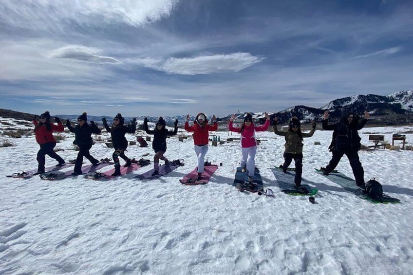 A group of people in winter sports attire on a snowy mountain with a clear sky. 5