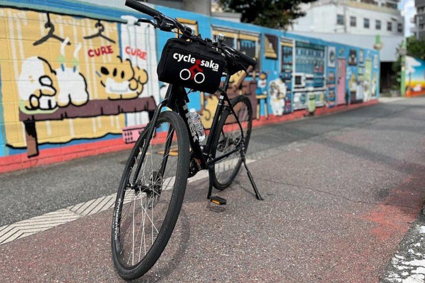 Un vélo noir avec un panier portant l’inscription « cycle sakia » est garé dans une rue. 3