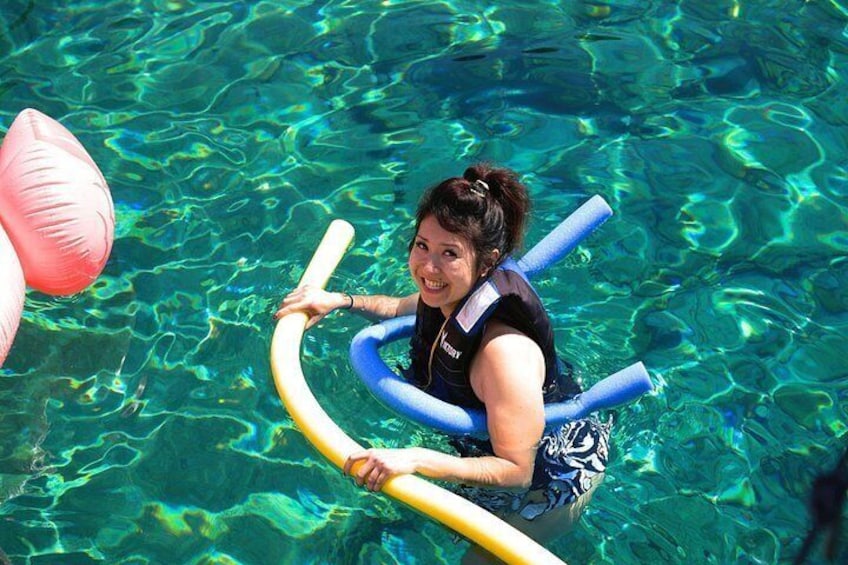 A person floating in a pool with a ring float and a pink flamingo float. 5