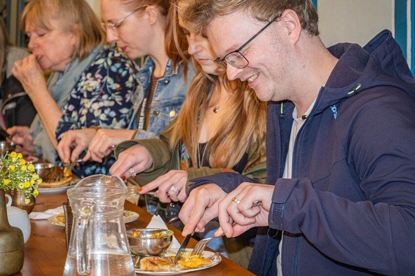 People dining at a table with food and drinks. 1