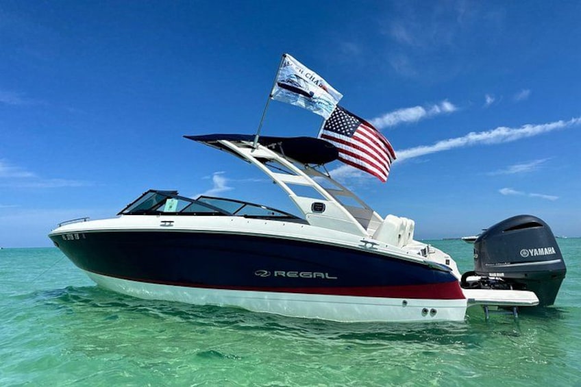 Ein Schnellboot namens 'REGAL' mit amerikanischer Flagge, einem Yamaha Außenborder und einem Wakeboard auf dem Wasser. 2