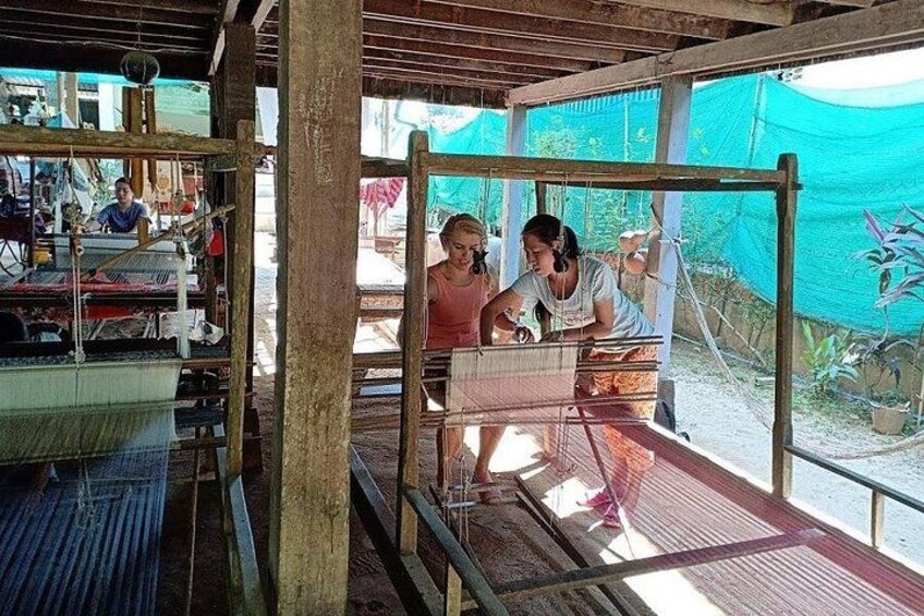 Un taller de tejido con dos mujeres trabajando en un telar. 2