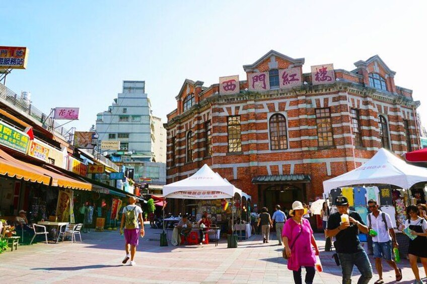 Een levendige openbare markt met bezoekers en verkopers onder partytenten. 2