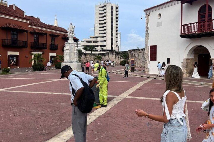A plaza with people, a statue, and buildings. 5