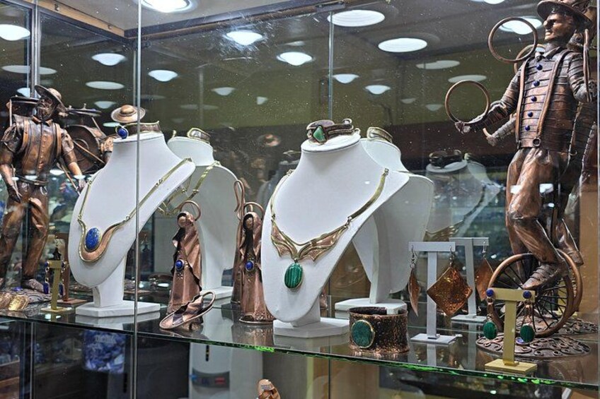 Ein Schmuckgeschäft mit verschiedenen Auslagen, darunter Halsketten, Armbänder und eine Statue. 3