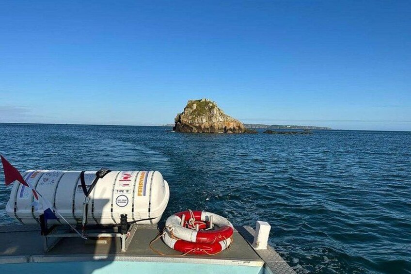 A boat with a life preserver and a white container on the deck. 2