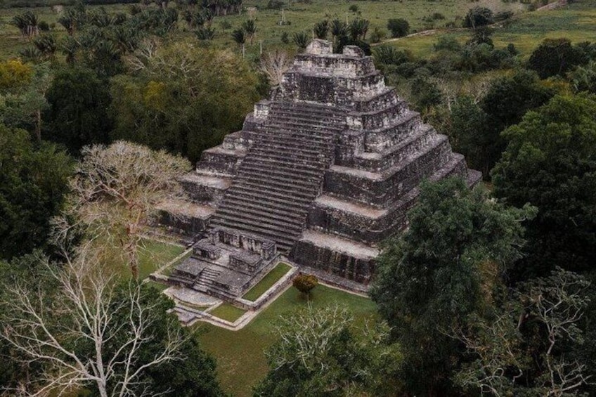 An ancient pyramid-like structure surrounded by dense greenery. 1