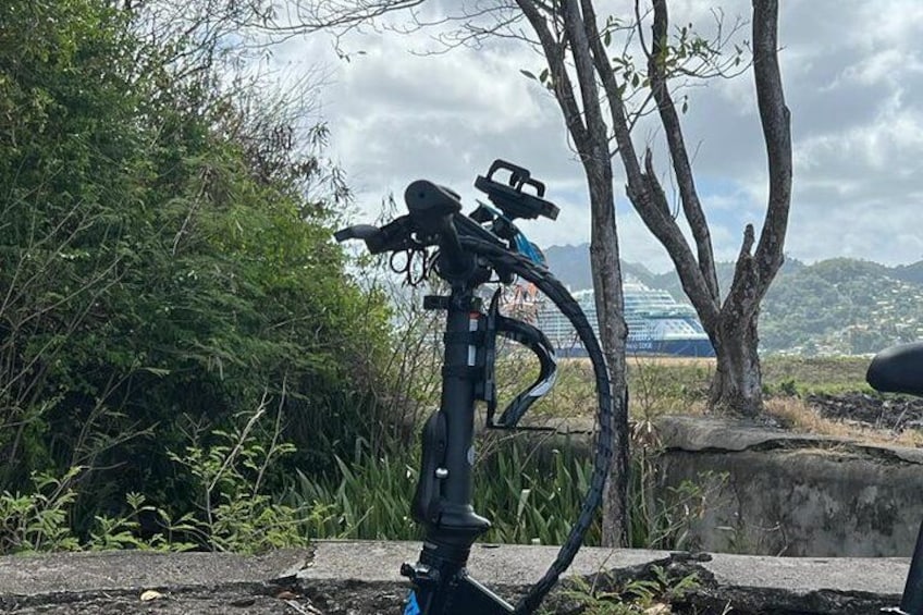 A bicycle mounted on a stand with a scenic view of mountains and a cloudy sky in the background. 4