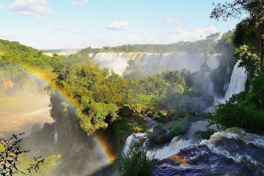 Een waterval stort neer in een rivier, omringd door weelderige begroeiing. 2