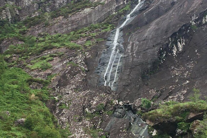 Une cascade se déversant en contrebas d’une falaise abrupte, le tout entouré d’une végétation luxuriante. 5