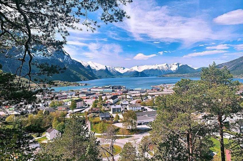 Una cittadina con case, un lago e montagne sullo sfondo. 1