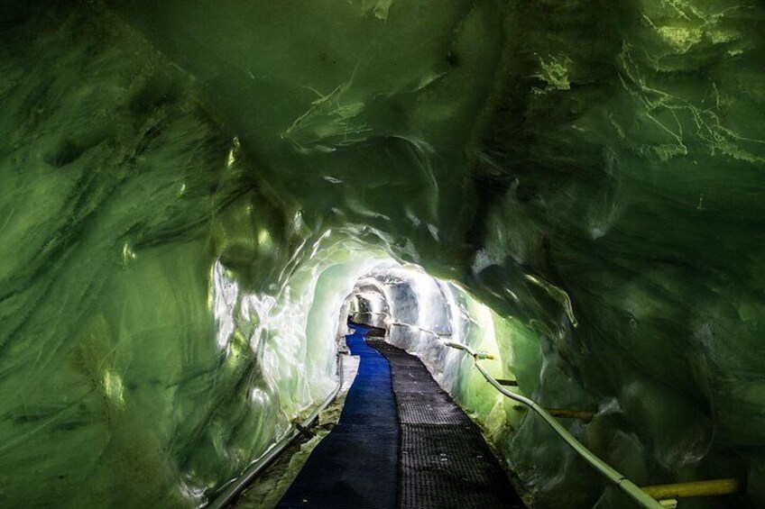 A tunnel with a blue pathway and green walls. 2