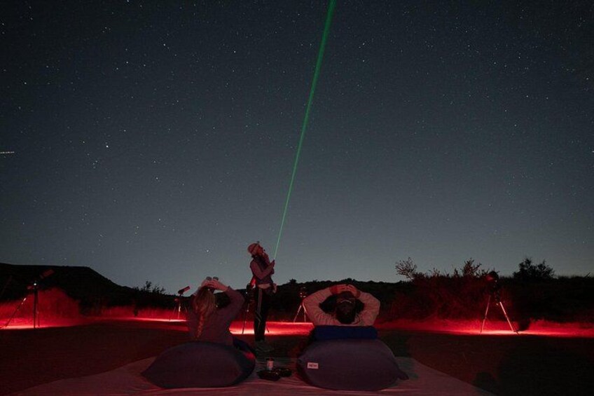 Ein Sternenhimmel, ein grüner Laserstrahl und Menschen, die zusehen. 2