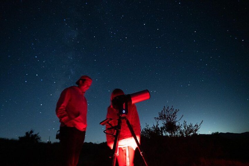 Two people observing the night sky through a telescope. 3