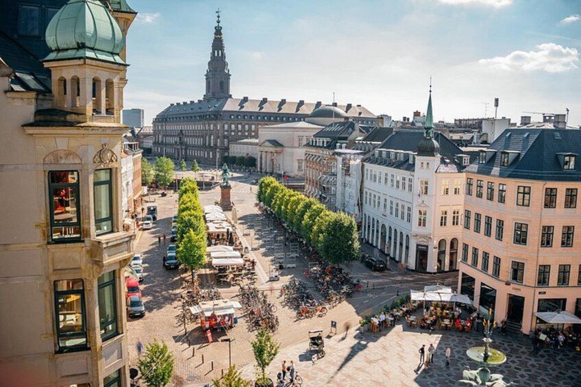 A city square with buildings, trees, and a distant tower. 5