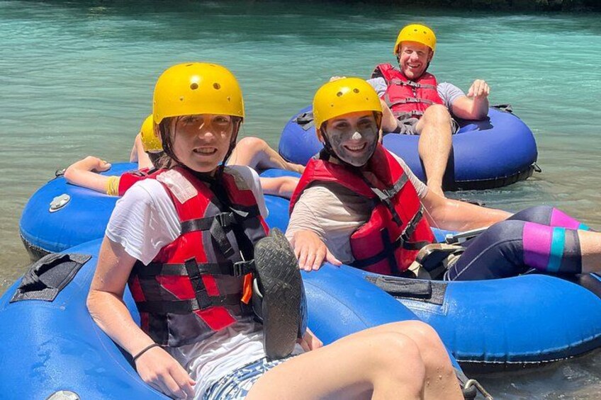 People in blue inflatable rafts wearing yellow helmets and red life vests. 2