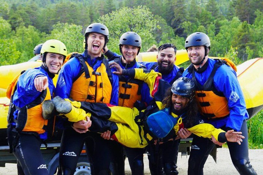 Un grupo de personas con chalecos salvavidas y cascos azules y amarillos, posando frente a una balsa inflable amarilla. 4