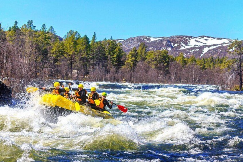 Un grupo de personas en un bote amarillo navegando un río con rápidos de agua blanca. 5