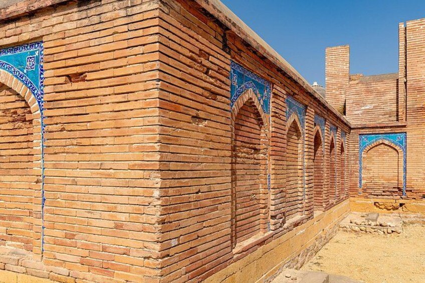 A brick building with blue decorative arches and a clear sky. 2