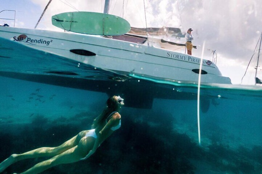 A person swimming underwater near a boat named "Stormy Pirate." 1