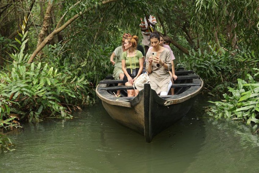 A boat with people on a river surrounded by dense vegetation. 4